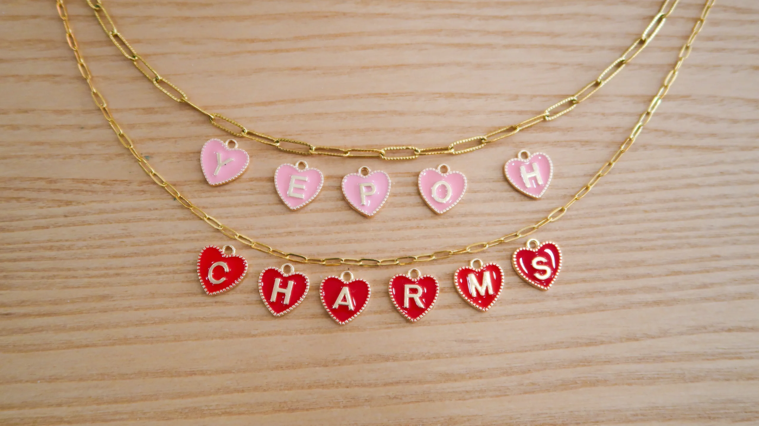 Custom layered necklaces adorned with colorful heart charms spelling out words